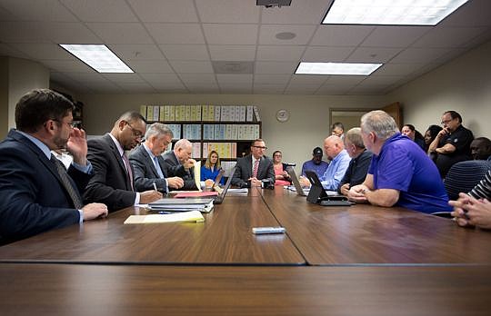 Mayor Lenny Curry sits at the head of the table Tuesday while addressing members of the Jacksonville Supervisors Association, right, about an initial offer on wages and pensions. Later in the day, city attorneys, left, met with the local Laborers' Int...