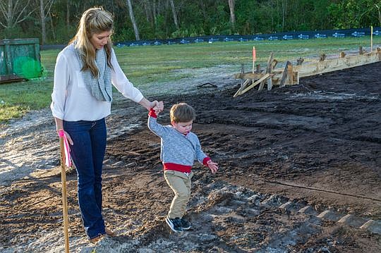 Sydney and Rhett Natto walk at the site of the family's new home in St. Augustine. Sydney's husband, Chris, is a Recon Marine who was injured during a parachute jumping exercise in February. Lennar Homes is leading the effort with dozens of other comp...