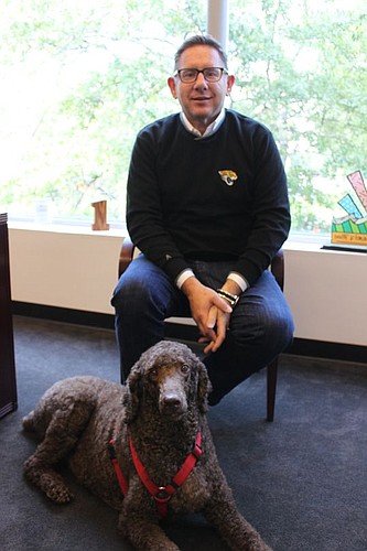 Michael Munz, Dalton Agency president of public relations, with his dog, Charlie, in his Downtown office that overlooks Hemming Park.