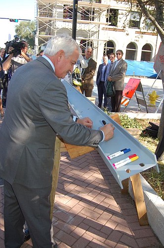 Friday morning, Cowford Chophouse owner Jacques Klempf put his signature on the last steel beam that will be installed at the top of the restaurant under construction Downtown at 101 E. Bay St. The "topping off" ceremony included placing a tree and un...