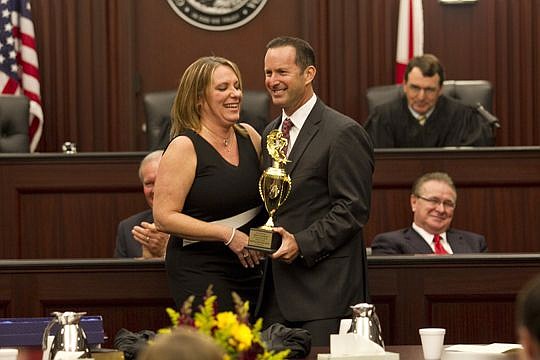 Mitch Stone presented Duval County Court Judge Kelly Eckley with a surfing trophy on behalf of The Jacksonville Beaches Bar Association during her investiture Wednesday. Eckley was a former chief assistant statewide prosecutor in the Florida Attorney ...