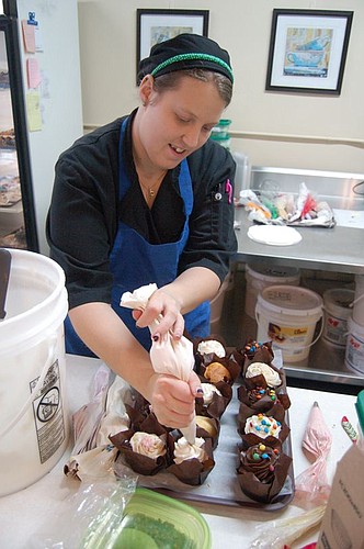 Jessica Proepper, formerly of Edgewood Bakery, decorates chocolate cupcakes.