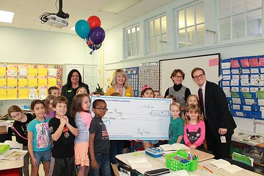 Susan Burns, second from right, was surprised in her classroom at Fishweir Elementary School with a $1,000 check for winning the Community First Innovation Prize.