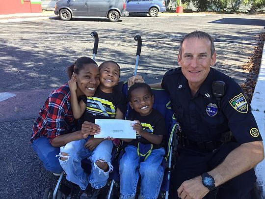 Officer Michael Ulsch presented a $100 gift card to a family. Members of the Sheriff's Offices in Jacksonville and Clay and Nassau counties gave out a total of $50,000 in gift cards Tuesday.