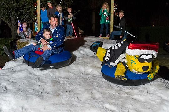 Jaxson de Ville takes a lead over Phillips and his son, Bennett, during a sledding race.