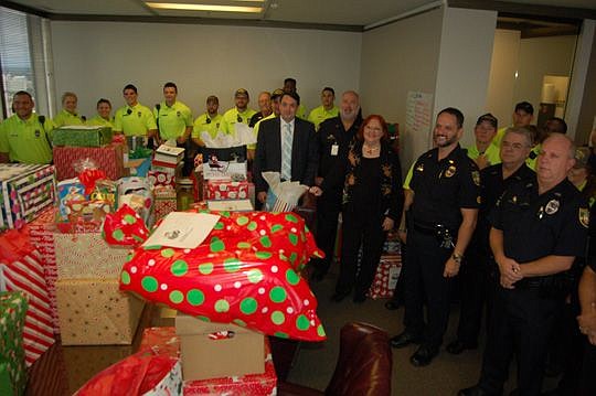 Attorney John Cherneski, 2016 chair of the JBA Holiday Project, and association Executive Director Susan Sowards with police officers and community service officers who helped deliver gifts to seniors.