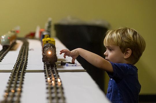 The Toy Train Collectors of Jacksonville set up a holiday toy train exhibit on the third floor of the Museum of Science and History in Downtown. Maxwell Lahey, 3, presses a button to make the train whistle as it passes by him Tuesday.