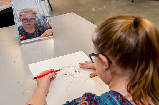 Ryan Griffin, 10, uses a mirror to check her image as she draws a self-portrait at the Museum of Contemporary Art Jacksonville's Winter Art Camp. The program offers half- and full-day sessions for students during the holiday break.