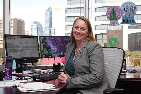 Laura Boeckman, North Florida bureau chief for the Consumer Protection Division for the Attorney General's Office, in her Downtown Jacksonville office. The artwork on the windows is courtesy of her four children.