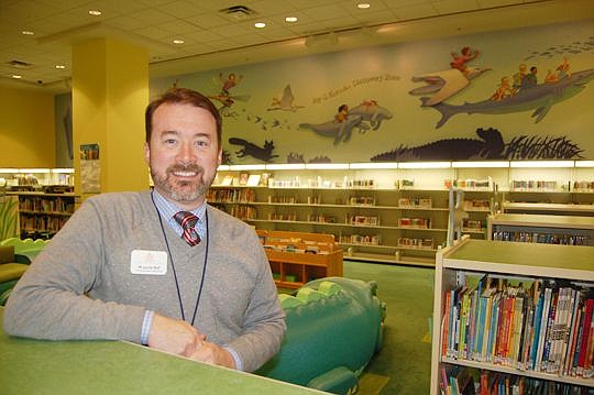 M. Jamie Self, executive director of the Jacksonville Public Library Foundation in the Children's Department at the Main Library Downtown. The mural behind him was one of the foundation's 2016 projects.