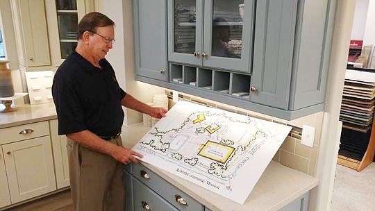 Lee Arsenault picks up sketches his company did for a nonprofit project with which he's assisting. Arsenault becomes president of the Northeast Florida Builders Association this month.