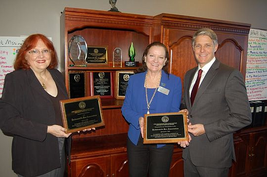 Jacksonville Bar Association Executive Director Susan Sowards, left; Kathy Para, chair of the JBA Pro Bono Committee; and association President Geddes Anderson were making room in the display cabinet Friday for the association's third Chief Justice's ...