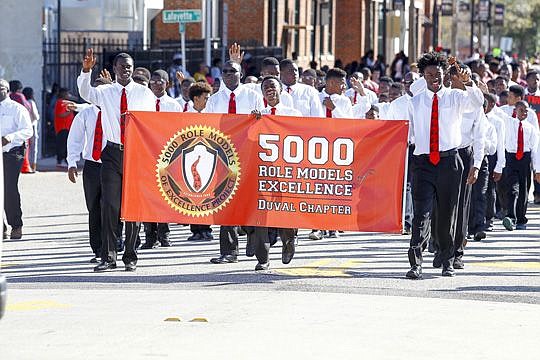 Students in the Duval County chapter of 5,000 Role Models of Excellence Project walk along Bay Street. The program provides positive role models to at-risk male youths in sixth-12th grades.