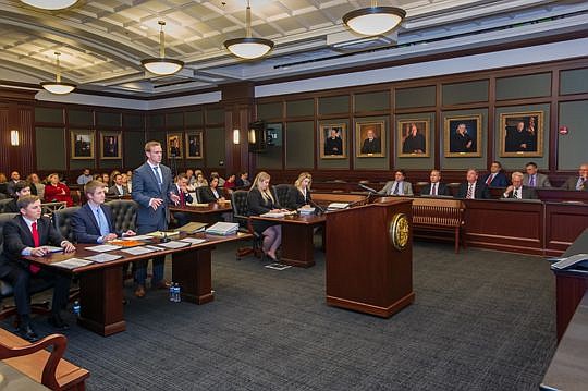 Skylar Stewart of Stetson University College of Law makes opening motions while the seven-member jury comprising attorneys looks on during the final round of the Chester H. Bedell Mock Trial Competition for teams from Florida's law schools. The compet...