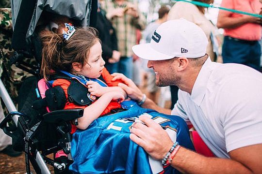 Tim Tebow talks to a child who attended the former Florida Gators quarterback's annual Celebrity Golf Classic last weekend at TPC Sawgrass Stadium Course in Ponte Vedra Beach. The two-day event is a fundraiser for the Tim Tebow Foundation.