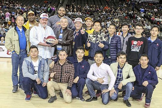 Jacksonville Giants owner Ron Sholes, standing third from left, presents an autographed ball from the American Basketball Association team to a delegation visiting from Yingkou, Liaoning, Jacksonville's sister city in China. He also owns the Law Offic...