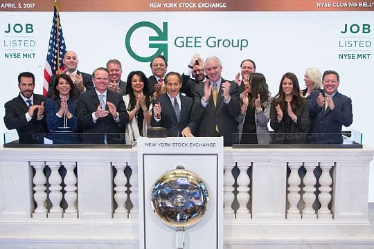 Officials of the GEE Group ring the bell to close the New York Stock Exchange on April 3.