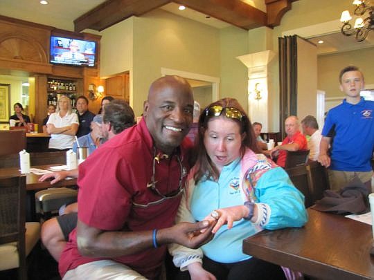 William Floyd, a Jacksonville native who played fullback at Florida State University and then in the NFL, lets Katelyn Atwell, a cancer survivor and former patient at St. Jude's Research Hospital, try on the ring he earned at Super Bowl XXIX.