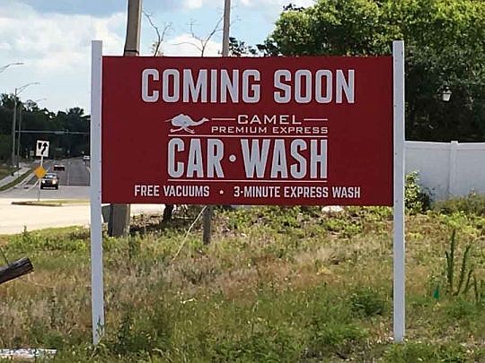A Camel car wash sign is up at 9094 Merrill Road in Arlington. The developer expects to start construction in two to three months.