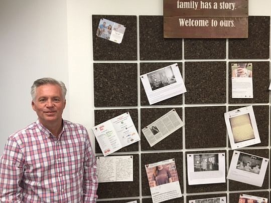 Maple Street Biscuit Co. co-founder Scott Moore  stands next to a board in the new office that features news and accomplishments about team members.