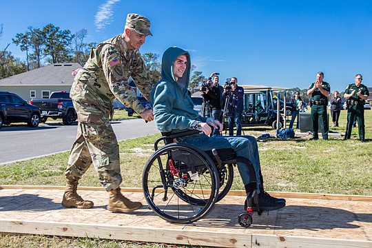 Natto's father-in-law Command Chief Warrant Officer, Florida National Guard, CW5 Jerry Dedge, assists Chris at the dedication of the family's new home.