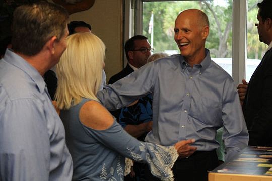 Gov. Rick Scott celebrates with supporters inside Angie's Subs in Jacksonville Beach, while outside protesters voice their displeasure for House Bill 7069. If it becomes law, the bill would shift some state and federal money from public to charter sch...