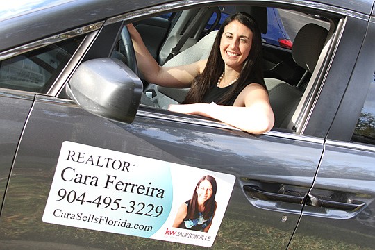 Cara Ferreira of Keller Williams Realty in her car, with its custom-made sign letting people know she's a Realtor.