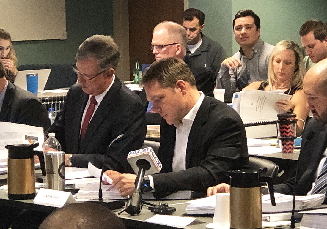 JEA Managing Director and CEO Aaron Zahn, center, reads his papers during a hearing Dec. 16 at City Hall about the utilityâ€™s Long-Term Performance Unit Plan that would have allowed employees to invest in the utility.