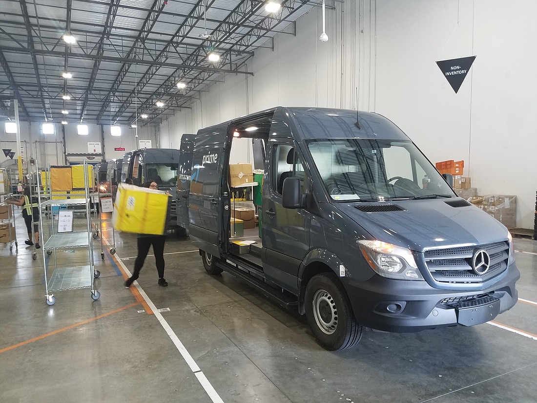 Vans are loaded inside the Amazon delivery station at 11084 Cabot Commerce Circle in the Alta Lakes Commerce Center.