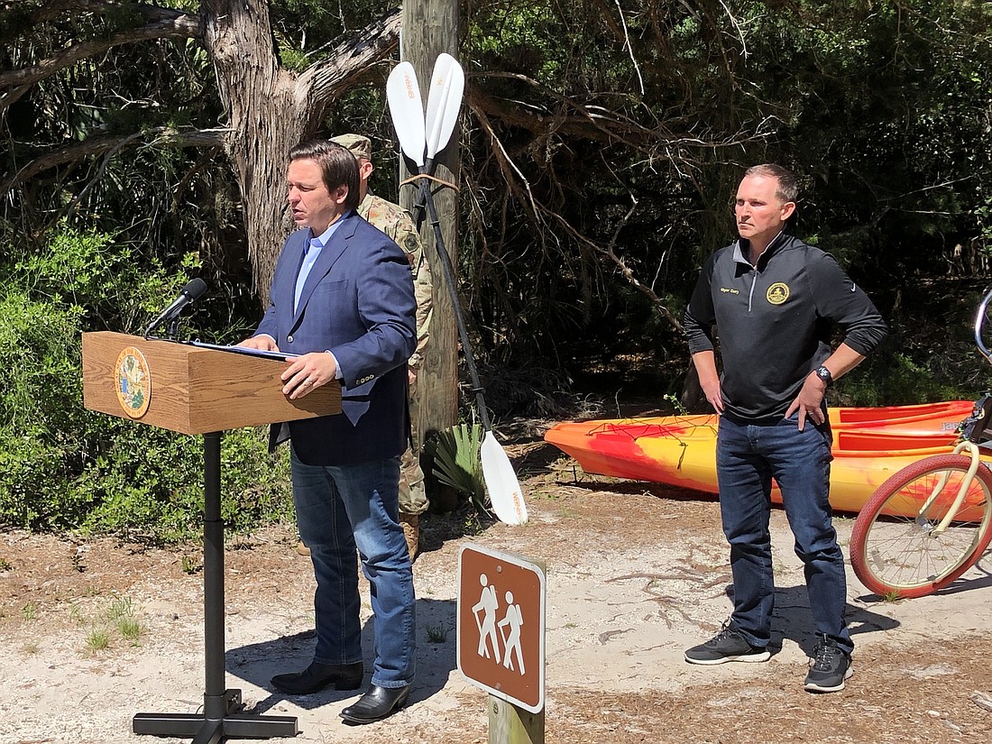 Gov. Ron DeSantis, backed by Jacksonville Mayor Lenny Curry, announces plans to reopen state parks at Little Talbot Island State Park.