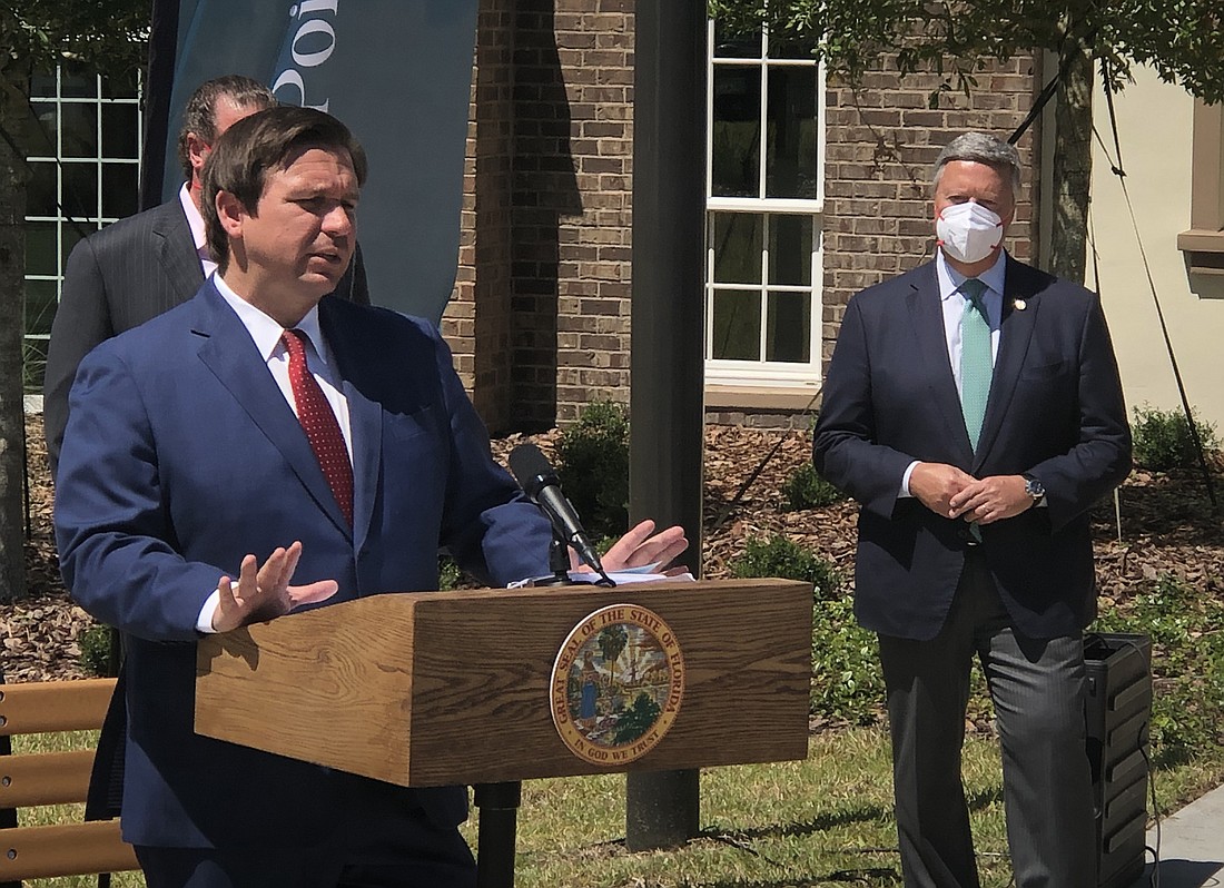 Gov. Ron DeSantis speaks May 8 at Dolphin Pointe Health Care. At right is Jacksonville University President Tim Cost.