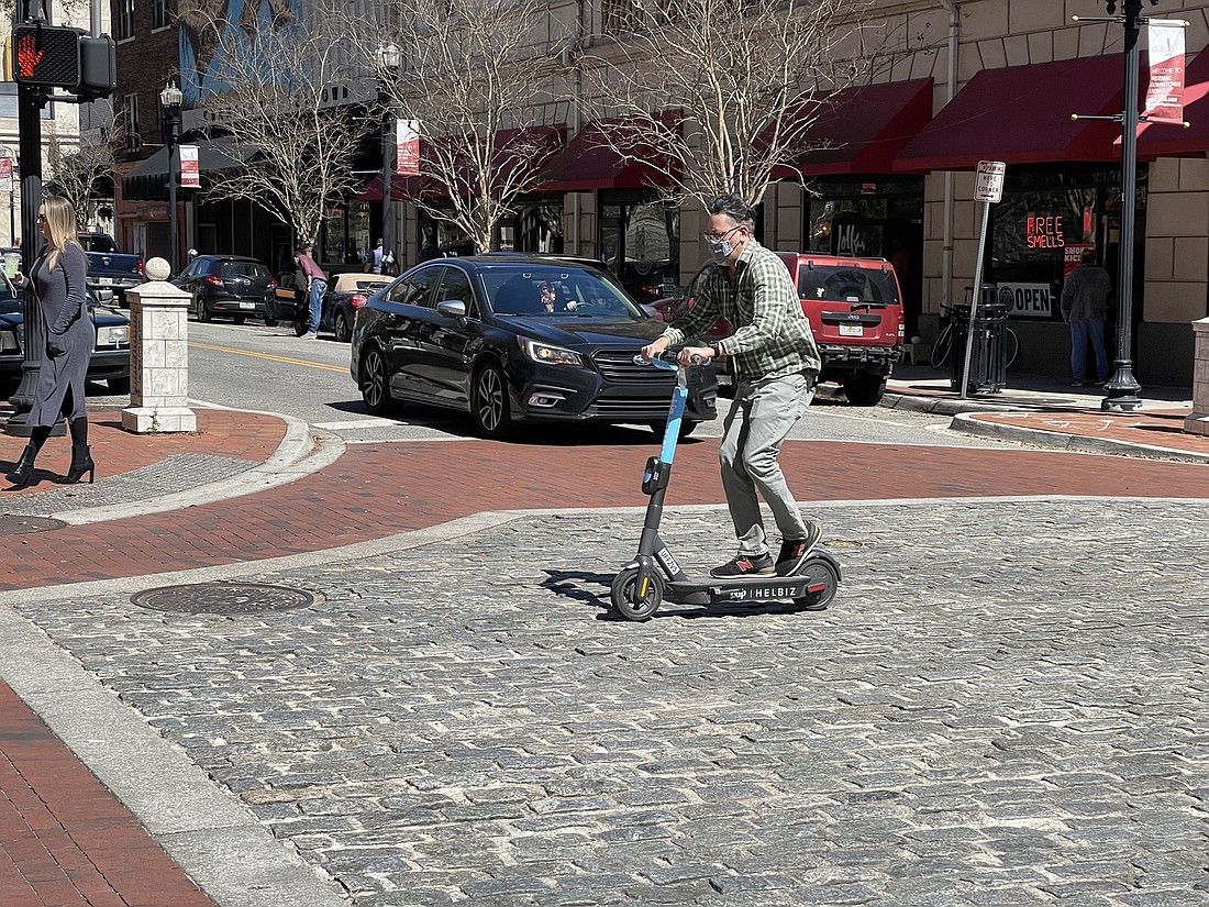 A scooter rider travels down Adams Street in Downtown Jacksonville.