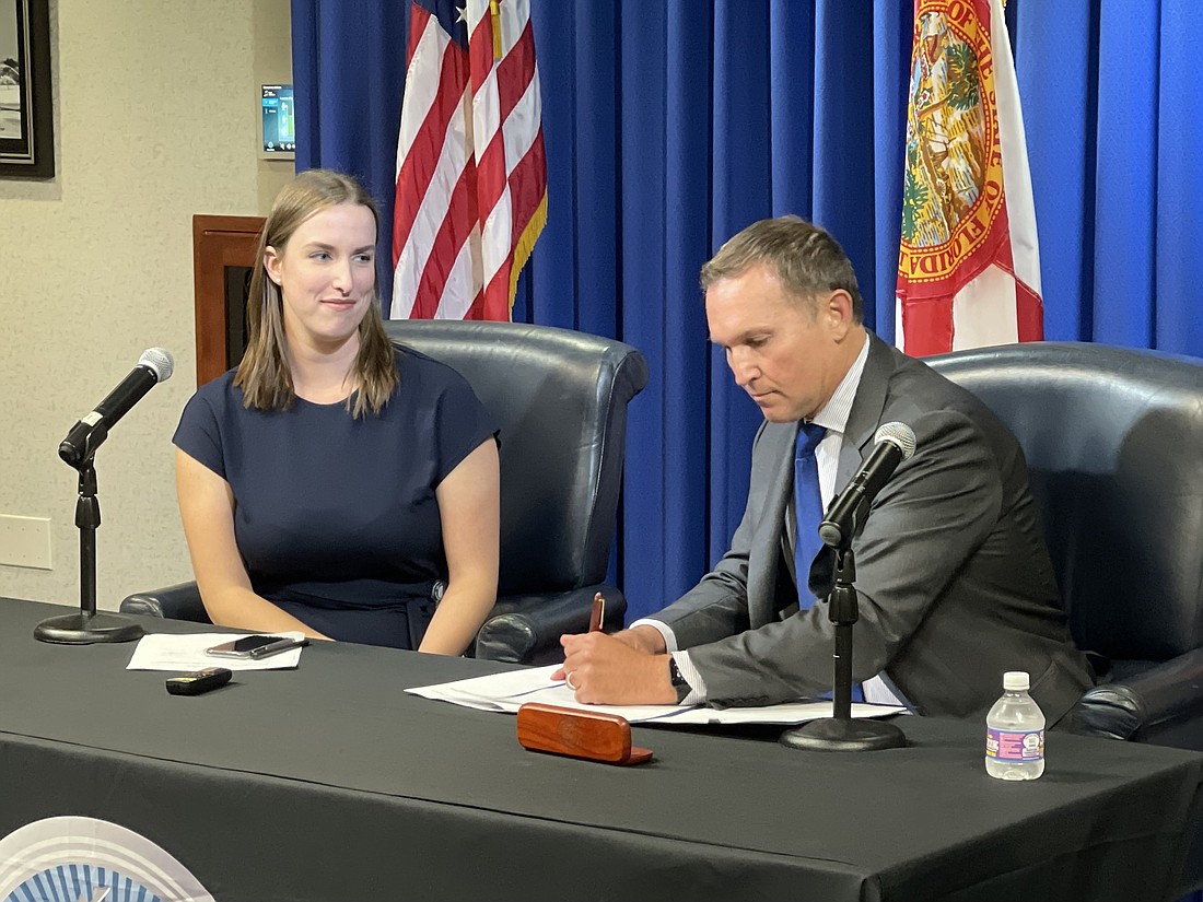 New city of Jacksonville Chief Resiliency Officer Anne Coglianese watches Jacksonville Mayor Lenny Curry sign the document finalizing her appointment Sept. 23.
