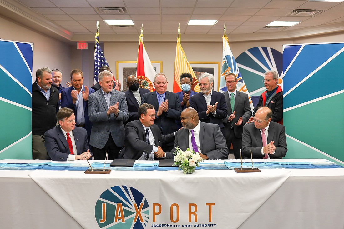 Ceres Terminals CEO Craig Mygatt, center left, shakes the hand of JaxPort CEO Eric Green after signing a$60 million lease and operating agreement Feb. 14 for the 158-acre container facility at the Dames Point Marine Terminal.