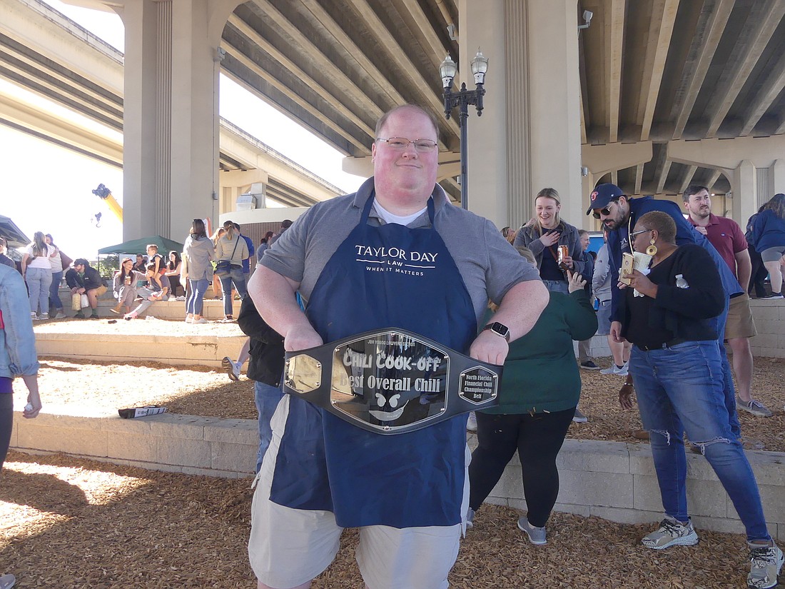 Ryan Reefe accepted the North Florida Financial championship belt on behalf of Taylor Day, the law firm team that won best overall in the 2022 Jacksonville Bar Association Young Lawyers Section Chili Cook-off.