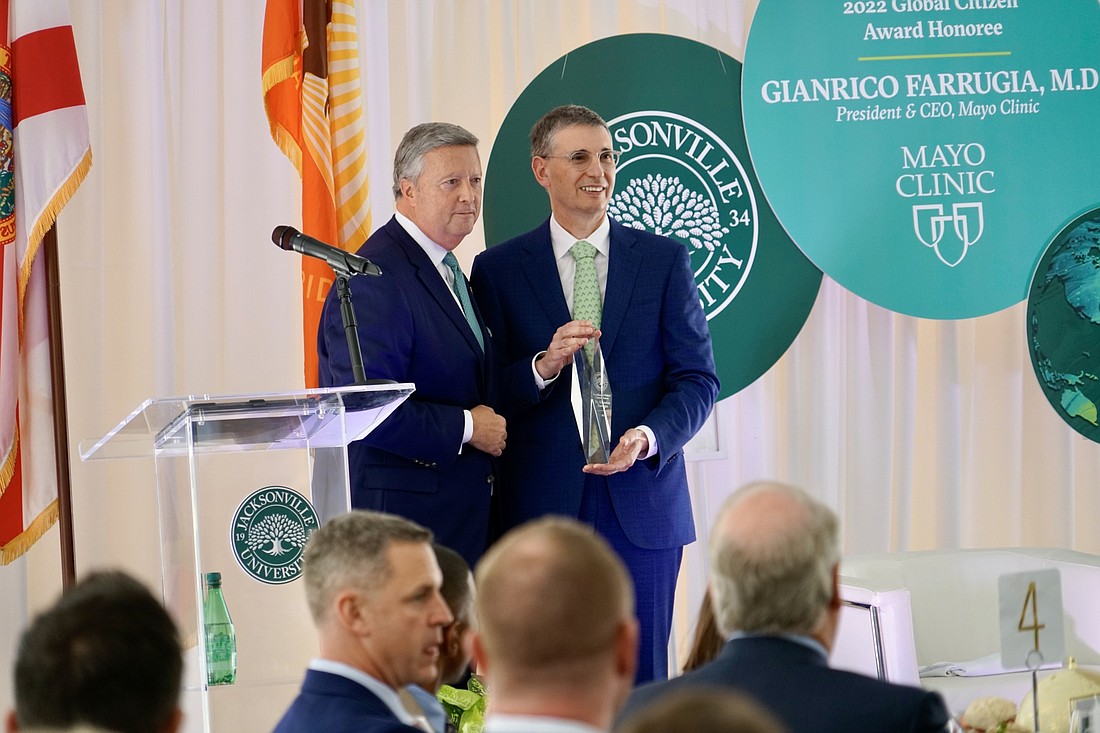 Mayo Clinic President and CEO Gianrico Farrugia, right, accepts the 2022 Presidential Global Citizen Award from Jacksonville University President Tim Cost.
