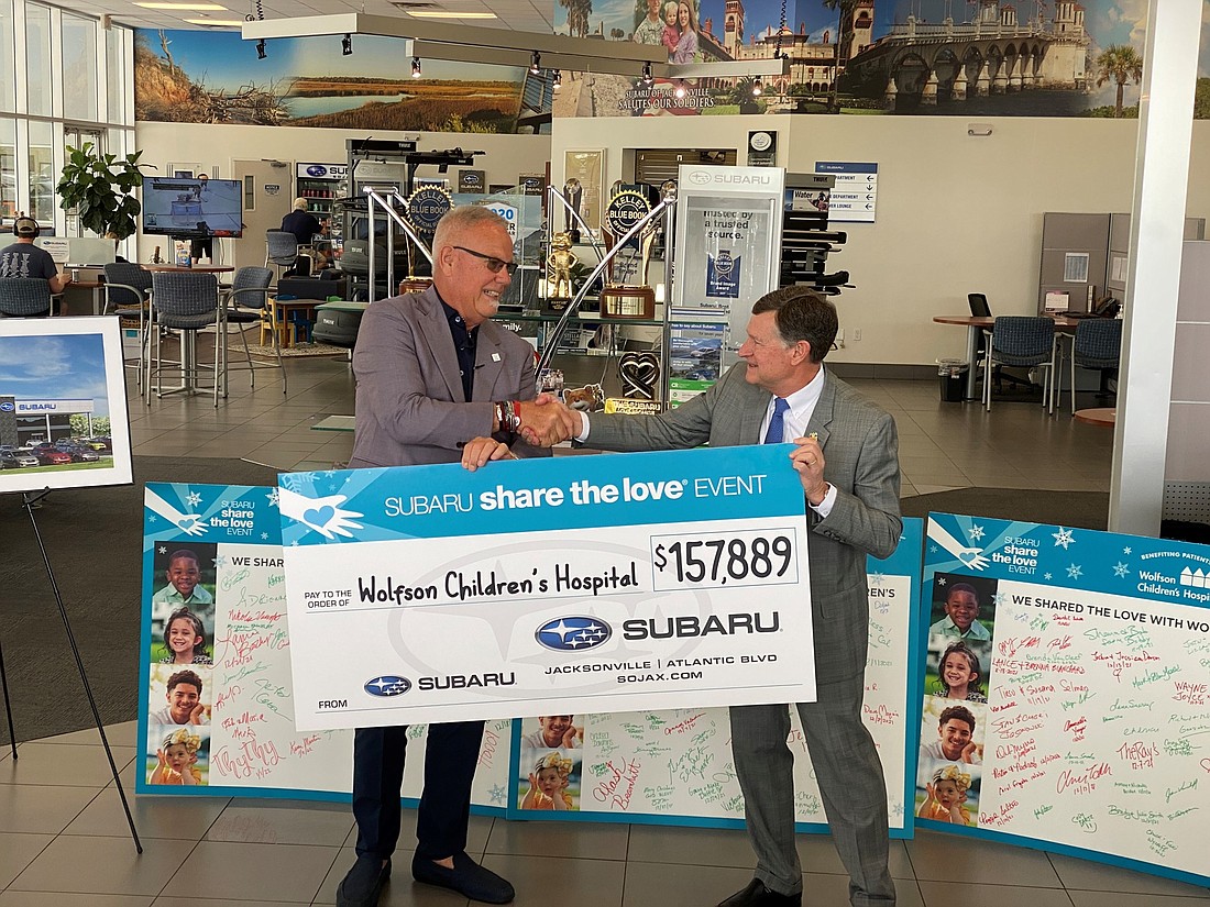 Phil Porter, owner of Subaru of Jacksonville, left, presents a donation to Wolfson Childrenâ€™s Hospital President Michael Aubin.