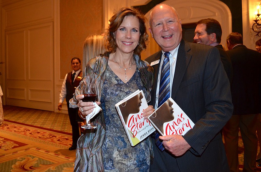 Jill Levine and Scott Anderson hold up the copies of Jenna Bush Hagerâ€™s book â€œAnaâ€™s Story: A Journey of Hopeâ€ that they received at the event.