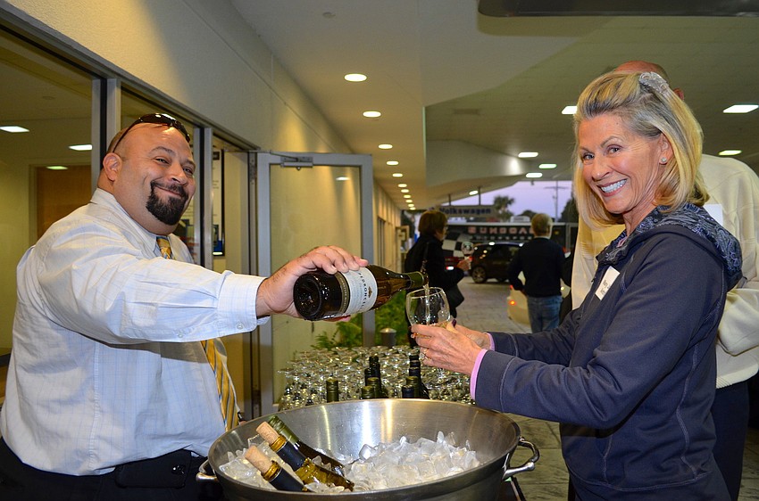 Carlo Giglio pours Mary Jane Antrim a sample of Pedroncelli Chardonnay at the Forks and Corks VIP Kickoff  Thursday, Jan. 23, at Suncoast Motorsports.