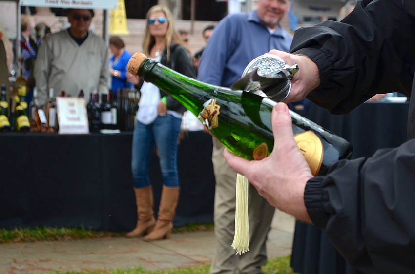 George Kehrt opens a bottle of champagne for guests.