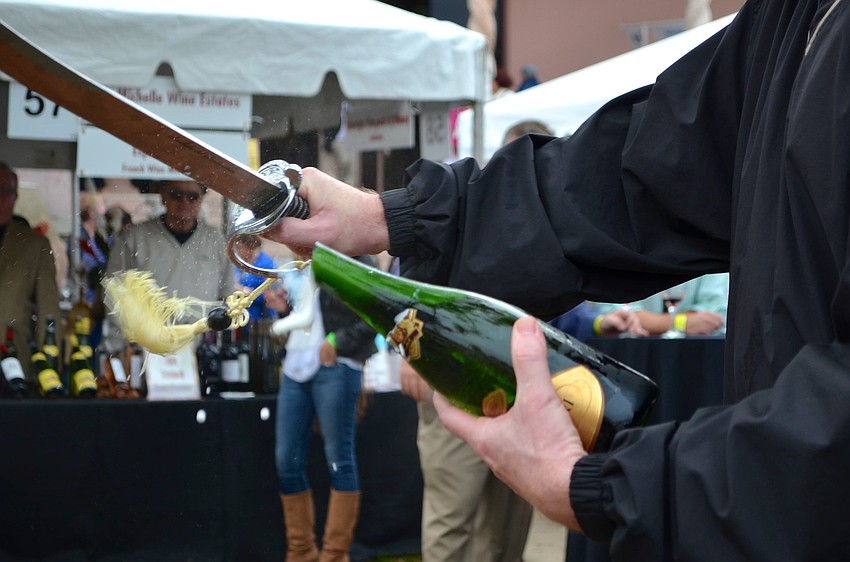 George Kehrt opens a bottle of champagne for guests.