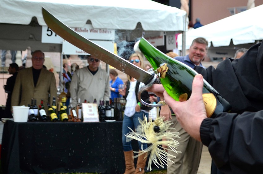 George Kehrt opens a bottle of champagne for guests.