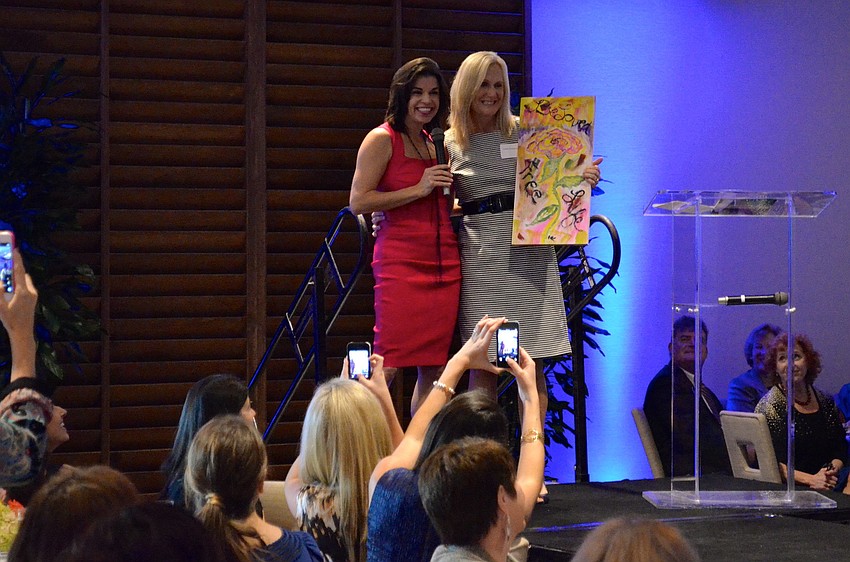 Elizabeth Fisher presents Cindy Pentecost with a painting done by one of Selah Freedomâ€™s survivors.