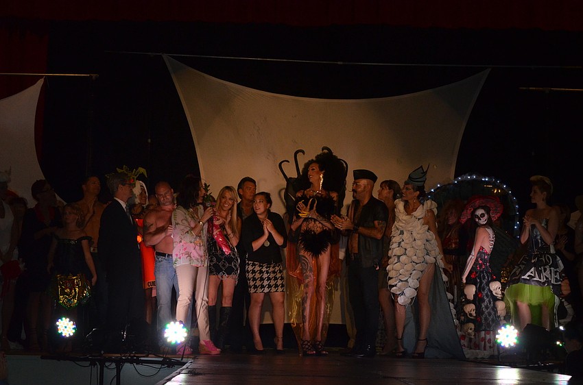 Models gather at the end of the fashion show and show of their outfits one more time.