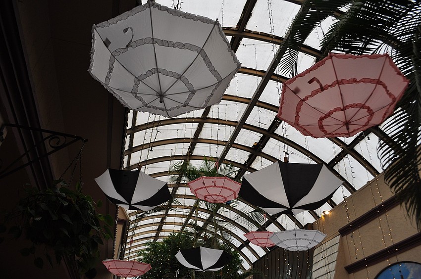 Pink, white and black parasols hung from the roof.