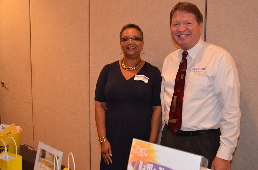 Phyllis Clay and Mike Beitzinger, SCLO volunteers, sell raffle tickets at the luncheon.