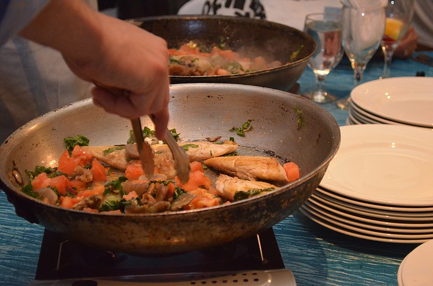 Guests at St. Marthaâ€™s Interactive Dinner take turns cooking each course for their table.