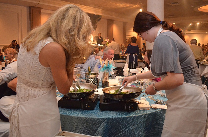 Michelle Jackson and Flannery Moran cooking at St. Marthaâ€™s Interactive Dinner.