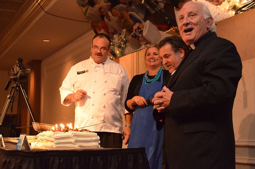 Jamil Pineda, Rebecca Blitz, Phil Mancini surprise Fr. Fausto Stampiglia with a birthday cake.