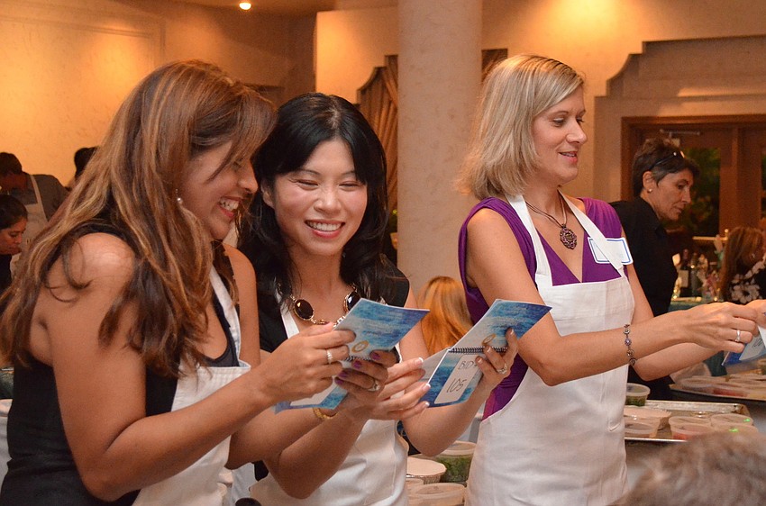 Vicki Skidmore, Yoaly Miller and Karen Strand read the instructions before they being cooking the first course.